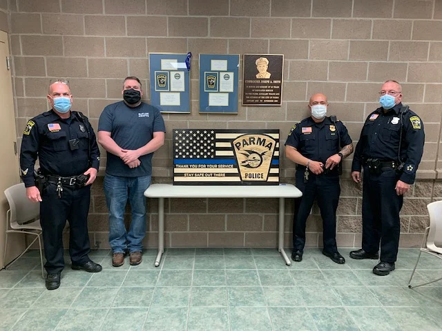 Bob Hutchinson delivering a hand-made thin blue line flag to four Parma Police officers